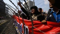 Massa menggelar aksi di depan kawat berduri yang dipasang di depan gedung Bawaslu.