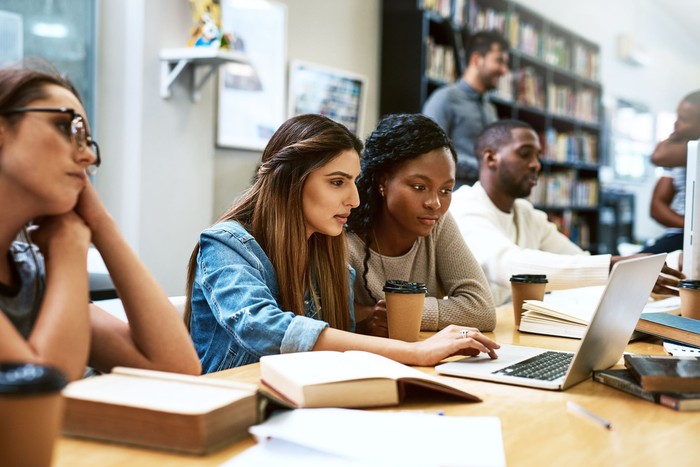 947895256 Shot of two young women using a laptop together in a college library