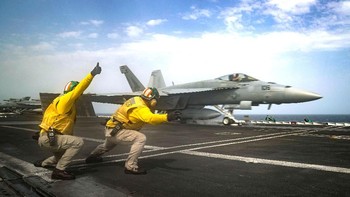 Kru memberi isyarat pada pesawat untuk terbang. Foto: Reuters