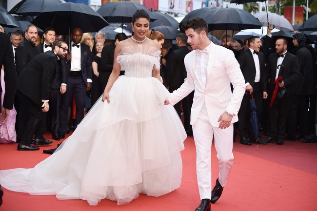 Gaun putih dramatis juga dipilih Priyanka Chopra untuk tampil di Cannes. Bak pengantin, ia hadir bersama sang suami Nick Jonas yang juga memakai jas putih. Gaun tulle yang dikenakannya merupakan keluaran dari koleksi bridal Georges Hobeika. Foto: Dok. Getty Images