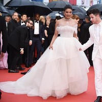 Gaun putih dramatis juga dipilih Priyanka Chopra untuk tampil di Cannes. Bak pengantin, ia hadir bersama sang suami Nick Jonas yang juga memakai jas putih. Gaun tulle yang dikenakannya merupakan keluaran dari koleksi bridal Georges Hobeika. Foto: Dok. Getty Images