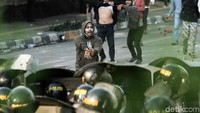 Massa tampak mendekati barikade polisi bertameng.