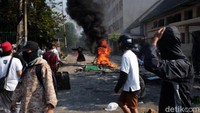 Massa mencoba bertahan di belakang api.