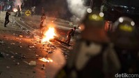 Massa membakar kayu di tengah jalan.