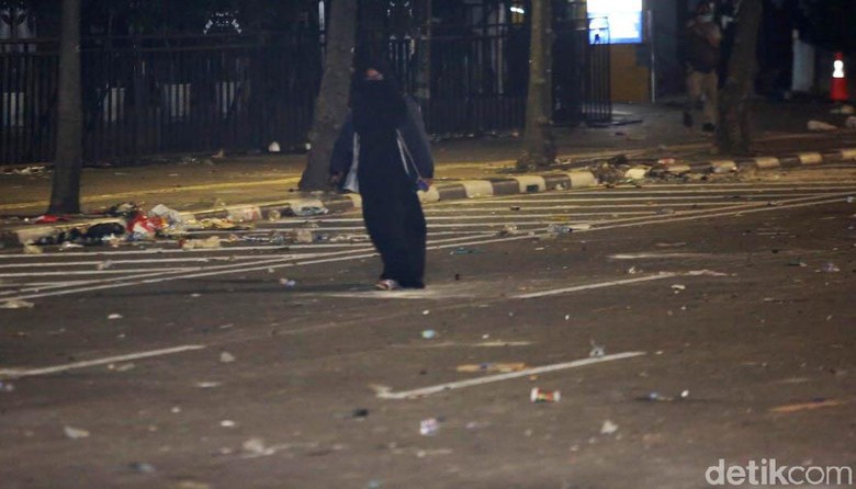 Perempuan Berpakaian Serbahitam dan Membawa Tas Berjalan ke Arah Bawaslu Perempuan Berpakaian Serbahitam dan Membawa Tas Berjalan ke Arah Bawaslu