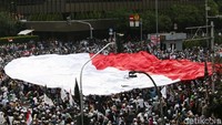 Massa aksi demo 22 Mei 2019 di depan gedung Bawaslu, Jakarta, membentangkan bendera merah putih raksasa, Rabu (22/5/2019).
