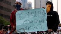 Peserta aksi membawa serta spanduk bertuliskan Kembalikan Kedaulatan Rakyat.