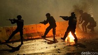 Aparat kepolisian terus berupaya membubarkan massa yang menyerang dengan tembakan gas air mata.