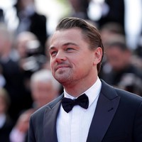 Leo tampak gagah dengan tuksedo berdetail lapel kulit. Ia pun melengkapi penampilan dengan dress shoes hitam mengkilap. Pria 44 tahun tersebut juga memakai kemeja putih berteksur yang dipadukan dengan dasi kupu-kupu. Foto: Getty Images