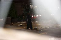 Perempuan Berpakaian Serba Hitam dan Membawa Tas Berjalan ke Arah Bawaslu
