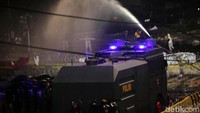 Water cannon dikerahkan untuk membubarkan massa.