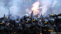 Polisi berusaha mengendalikan massa.
