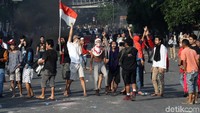 Massa nampak membawa serta bendera merah putih saat bentrok dengan polisi.