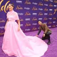 Momen menarik terjadi ketika tiba giliran Naomi Scott difoto sendiri. Seperti seorang asisten pribadi, Mena sempat merapikan ekor gaun Naomi sampai harus berlutut sebelum rekannya dipotret. (Foto: Getty Images)