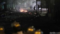 Beberapa orang masih bertahan dan melempari polisi dengan batu dan kembang api.