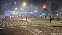 Di antara massa dan polisi dibatasi separator beton. Polisi juga menyemprotkan air ke arah massa lewat mobil water cannon. Meski kena semprot air, massa tak bergeming. 