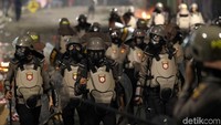 Polisi memakai masker untuk menghindari gas air mata.