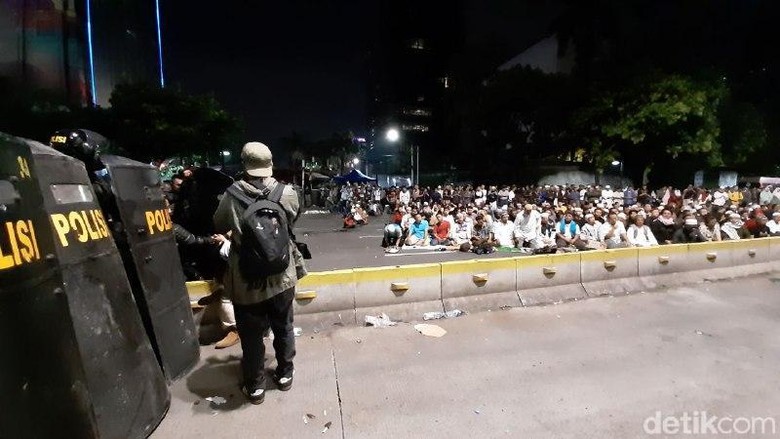 Massa Pendemo Salat Isya Berjemaah di Depan Bawaslu Massa Pendemo Salat Isya Berjemaah di Depan Bawaslu