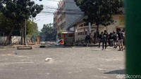 Bebatuan nampak tercecer di jalanan usai dilemparkan oleh massa.