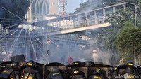 Polisi membawa serta tameng untuk menghindar dari lemparan batu yang dilakukan oleh massa aksi di kawasan Tanah Abang, Jakarta.