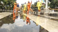 Petugas PPSU bahu membahu membersihkan lokasi.