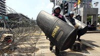Polisi nampak membawa papan pelindung saat bersiaga di sekitar gedung Bawaslu, Jakarta.