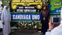 Sejumlah pengunjung nampak berfoto di sebelah karangan bunga duka cita yang dikirimkan Sandiaga Uno.
