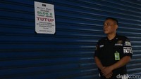 Seorang petugas keamanan berpatroli di sekitar Pasar Tanah Abang, Jakarta. Pengumuman tutupnya Pasar Tanah Abang pun turut diinformasikan melalui selembaran yang ditempelkan di sejumlah dinding ruko di pasar tersebut.