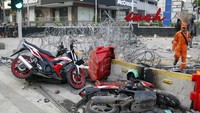 Tampak ada motor-motor rusak yang teronggok di dekat kawat berduri. 