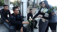 Seorang mahasiswi membagikan bunga kepada anggota kepolisian yang tengah berjaga di Bawaslu, Jakarta, Kamis (23/5/2019).