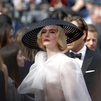 Turut menyempurnakan gaya old Hollywood glam sang bintang Malificenet 2 ini, sebuah topi makrame hitam bertema vintage dengan sepasang heels hitam yang dihiasi tali bersilang. Sebagai sentuhan akhir, lipstik merah merona yang memulas bibir Elle. (Foto: Getty Images)