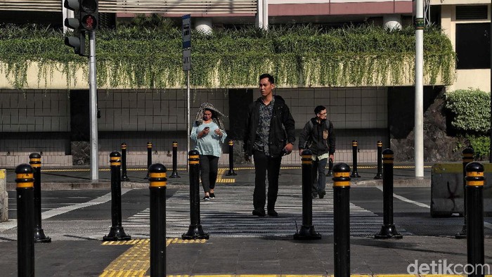 Para pekerja di kawasan Jalan MH Thamrin, Jakarta Pusat, mulai beraktivitas normal. Para pekerja kantoran ini terlihat hilir mudik.