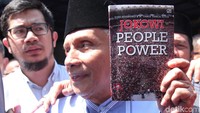 Amien menunjukkan buku berjudul Jokowi People Power yang ia bawa saat memenuhi panggilan polisi untuk diperiksa terkait pernyataan people power yang disampaikan tersangka Eggi Sudjana.