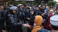 Seorang peserta aksi mengulurkan tangan kepada polisi untuk saling memaafkan dalam aksi damai di depan gedung Bawaslu, Jakarta.