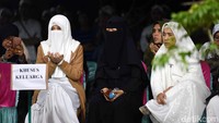 Ketiga istri almarhum tampak duduk dan berdoa di dekat liang lahat. Pool/Noel/detikFoto.