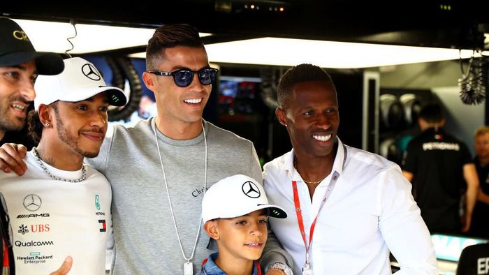 Cristiano Ronaldo berpose dengan Lewis Hamilton di paddock tim balap Mercedes di sela-sela GP Monako. (Foto: Mark Thompson/Getty Images)
