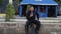 Seorang anggota Brimob beristirahat sejenak di sela-sela tugasnya mengamankan kawasan Bawaslu. 