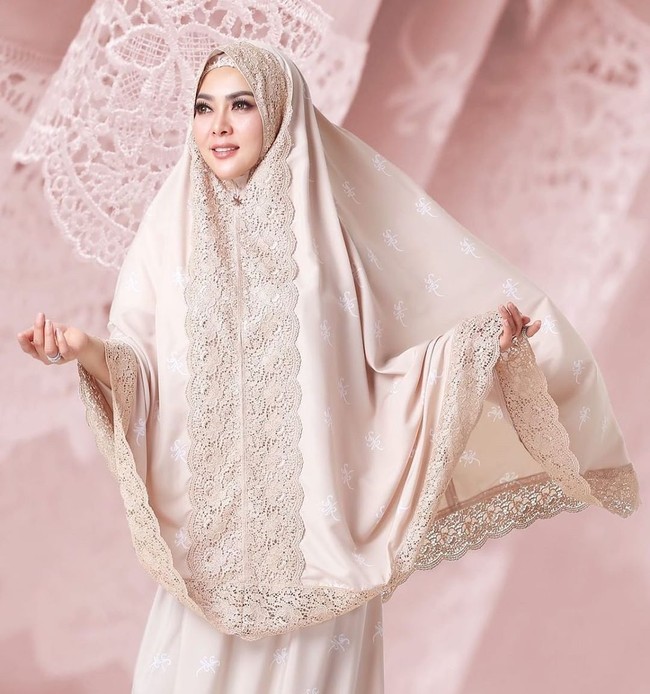 Syahrini kembali membuat netizen terpana saat meluncurkan koleksi mukena untuk Lebaran 2019 dengan logo berlapis emas 24 karat seharga Rp 3,5 juta. Mukena Syahrini itu memiliki desain simple dengan aksen lace yang manis di bagian dahi. Berbeda dengan mukena pada umumnya, tali kepala ada di bagian dalam sehignga tidak mudah jatuh saat salat. Syahrini mengungkap, mukena ini menggunakan bahan spesial yang eksklusif dibuat untuk dirinya dan tidak akan ditemukan pada produk lain. Foto: Instagram/FatimahSyahrini