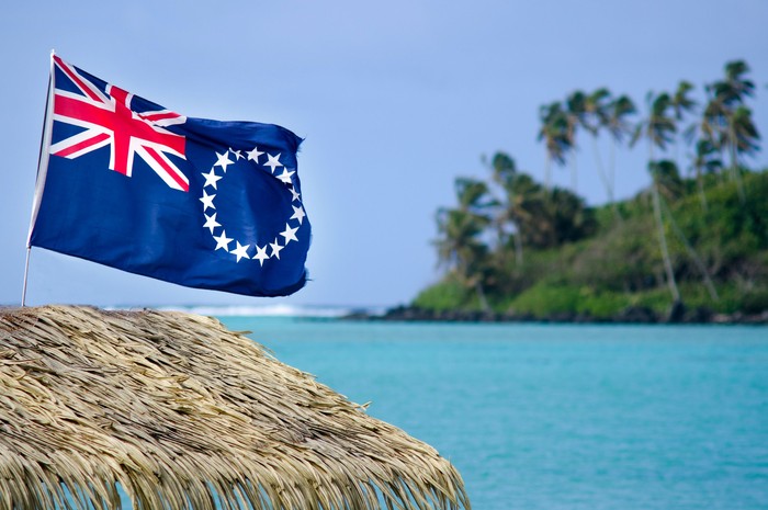 The flag of the Cook Islands, officially known as the Cook Islands Ensign, wave in the wind at Muri Lagoon in Rarotonga, Cook Islands.
