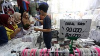 Pedagang tampak sibuk melayani pembeli yang memadati area toko mereka. 