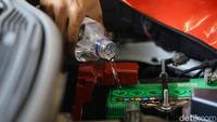 Seorang mekanik nampak sibuk mengisi air aki ke mobil Mitsubishi di bengkel Mitsubishi Semarang, Jawa Tengah.