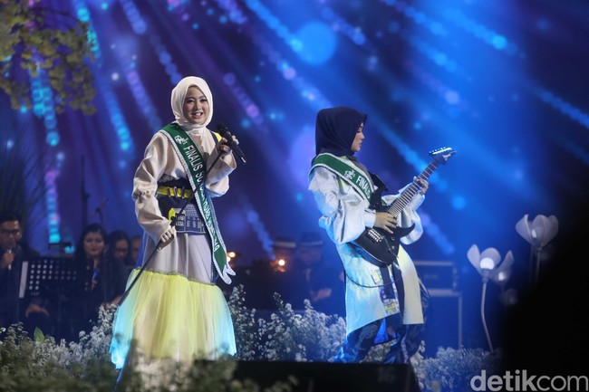 Pada segmen pertama grand final Sunsilk Hijab Hunt 2019, dua finalis Lisa Yuandira dan  Delvi Afriwanda tampil. Keduanya membawakan lagu Bohemian Rhapsody dari Queen sesuai dengan bakat masing-masing. Delvi lolos ke babak ini berkat permainan gitar dan penampilan rocker. Di panggung final, ia memainkan gitar listrik mengiringi suara Lisa yang merdu. Foto: Pradita Utama/Detikcom