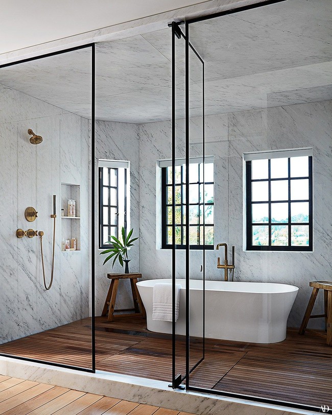 Kamar mandi utama di rumah Jessica Alba hadir dengan dinding berlapis marmer bernuansa putih. Pancuran dan bathtub digabung dalam satu ruangan yang dibatasi pintu kaca. (Foto: Dok. Architectural Digest)