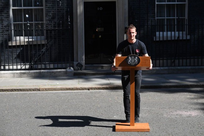 Momen pidato pengunduran diri Perdana Menteri Inggris Theresa May beberapa waktu lalu membuat seorang pria mendadak viral. Dia bukan pengganti Theresa, melainkan seorang teknisi audio yang mempersiapkan podium untuk Theresa berpidato di depan rumah dinas PM Inggris di 10 Downing Street, London. (Foto: Leon Neal/Getty Images)