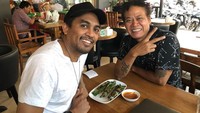 Berfoto bersama seniman Tony Q, Glenn terlihat sedang menikmati otak-otak yang dicocol sambal kacang. Foto: Instagram@glennfredly309