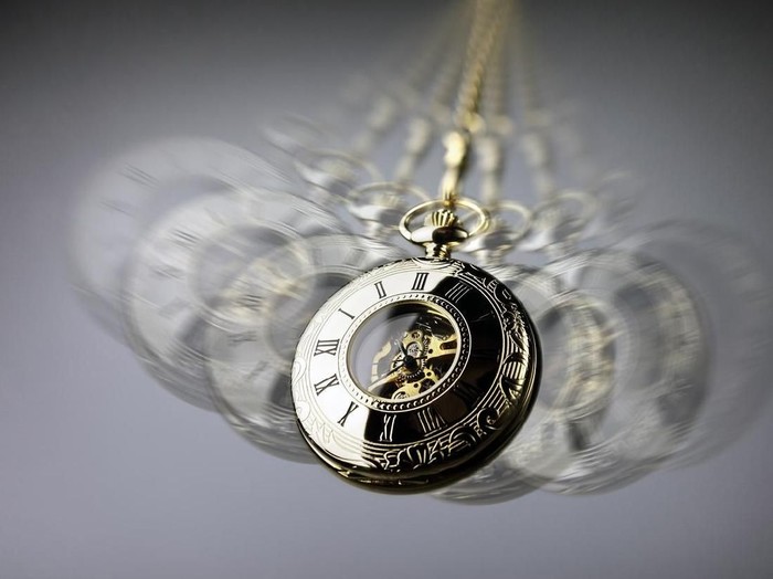 Hypnotism concept, gold pocket watch swinging used in hypnosis treatment