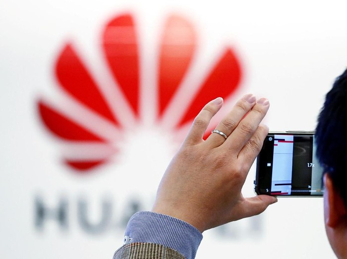 Ilustrasi seseorang memotret logo Huawei. Foto: Reuters Ilustrasi seseorang memotret logo Huawei. Foto: Reuters