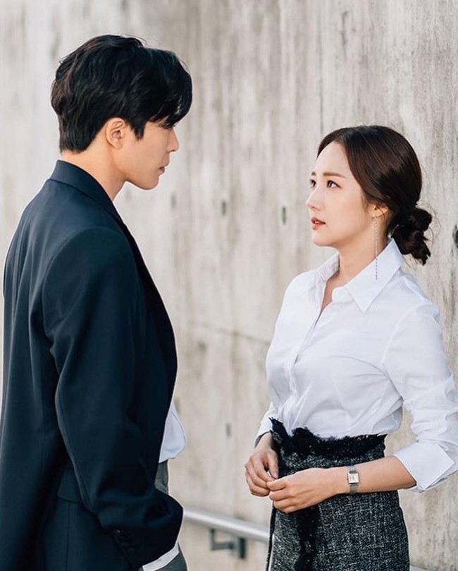 Selain setelan blazer dan celana, para wanita karier biasanya juga mengenakan padanan kemeja dan rok. Agar gaya lebih segar, hindari selalu pakai rok sepan dan cari opsinya yang atraktif seperti berikut ini. Foto: TvN