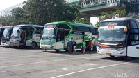 Awak bus menunggu keberangkatan sambil menyambut penumpang yang datang.