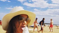 At the beach 😜😜 #latepost #melbourne, tulis gadis cilik yang punya saluran YouTube ini. Wah, ternyata Shabina makan es krimnya di pantai Melbourne. Foto: Instagram shabinamecca